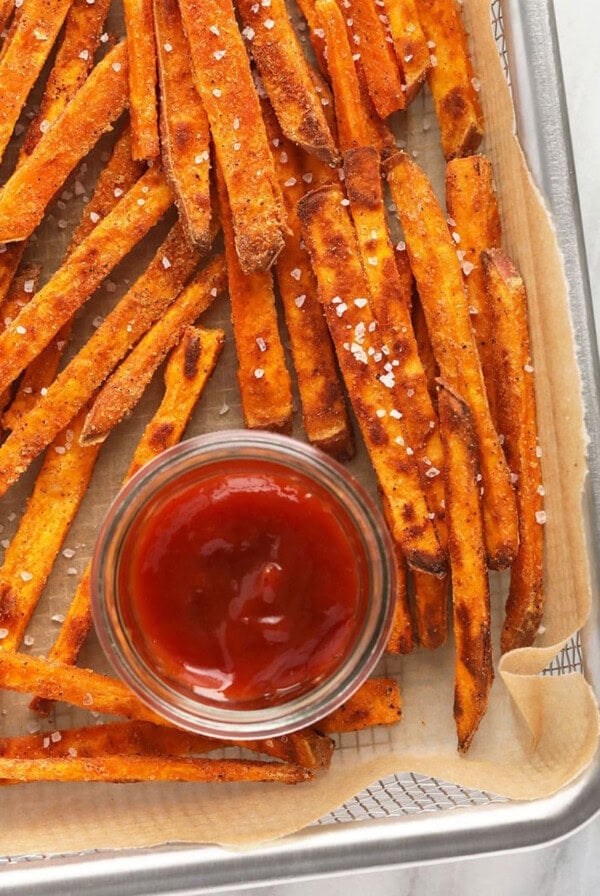 sweet potato fries on a baking sheet with ketchup.