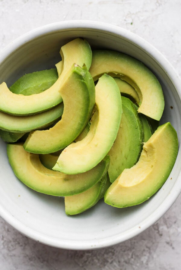 sliced avocado in a white bowl.