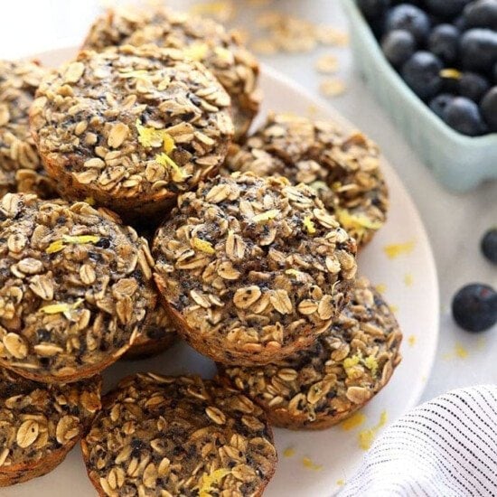 a stack of blueberry oatmeal muffins on a plate.