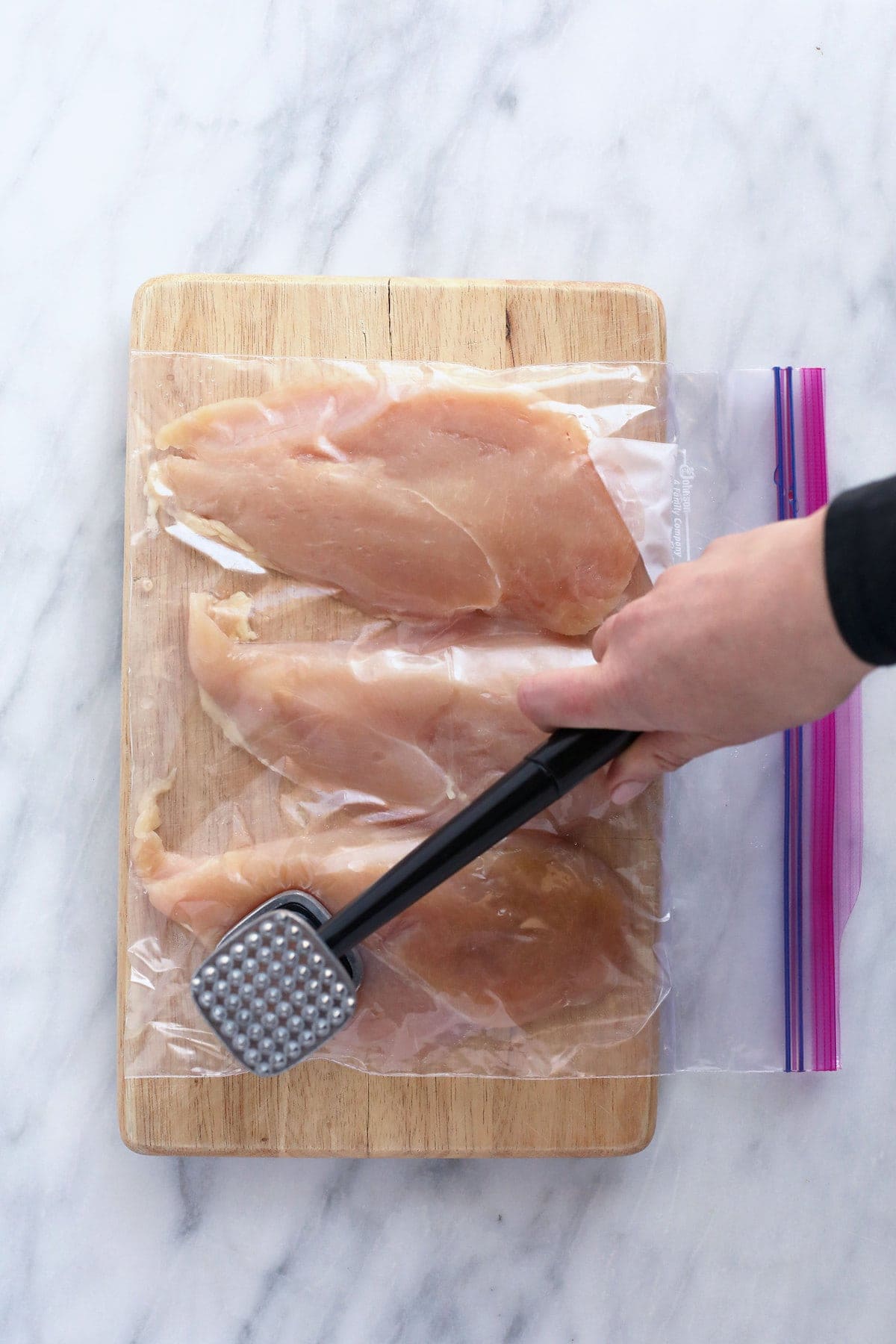 pounding chicken with meat tenderizer