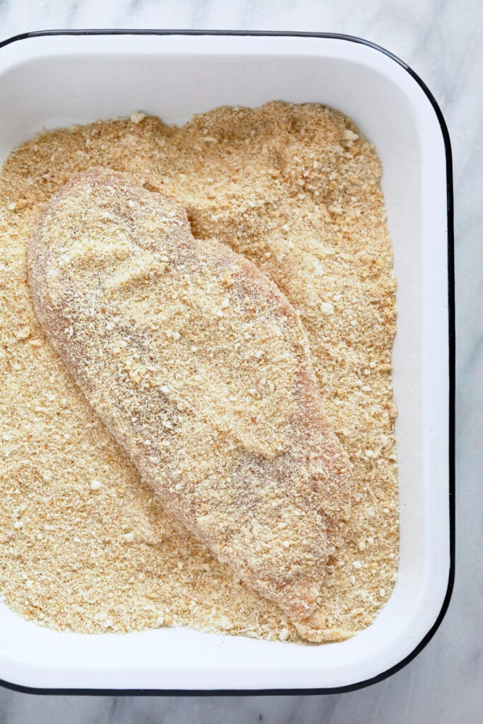 dredging chicken in bread crumbs and parmesan cheese