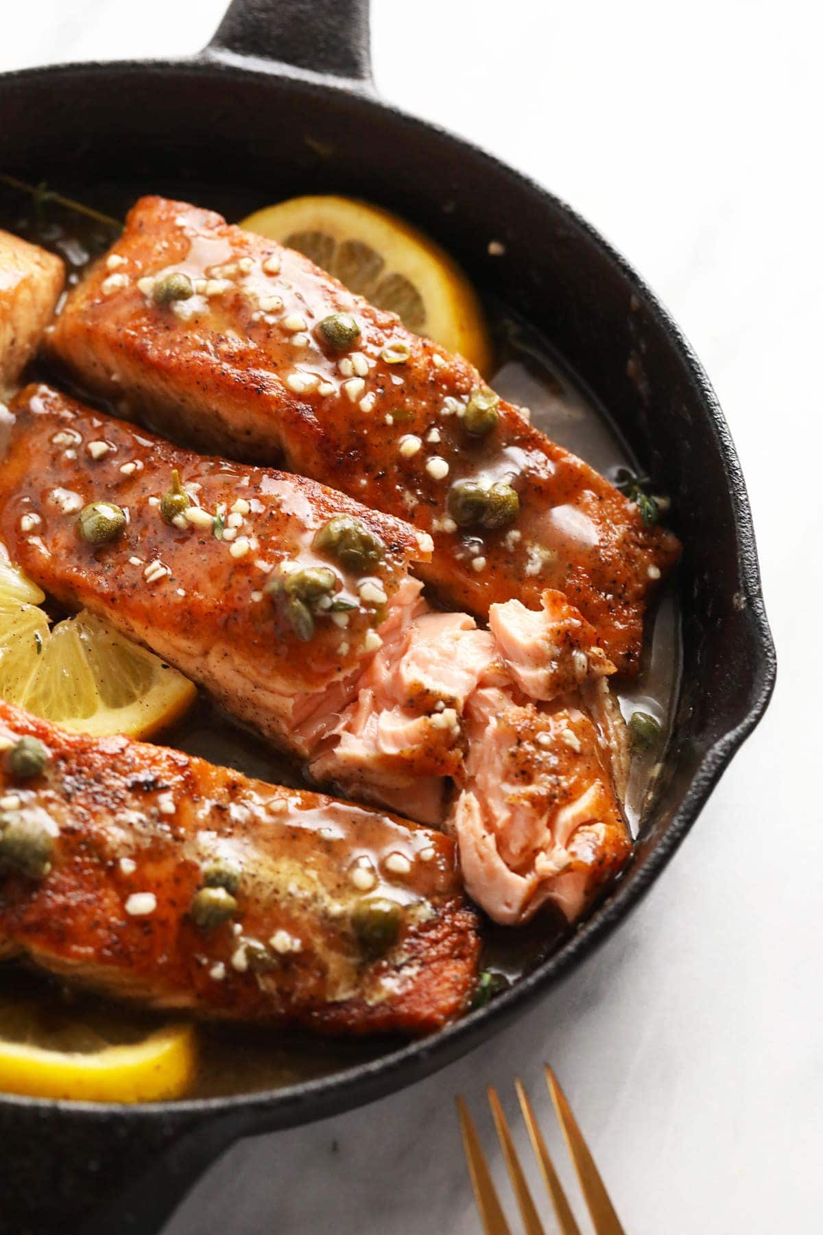 Salmon piccata in a cast iron pan, 