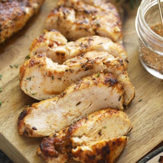 grilled chicken on a wooden cutting board.