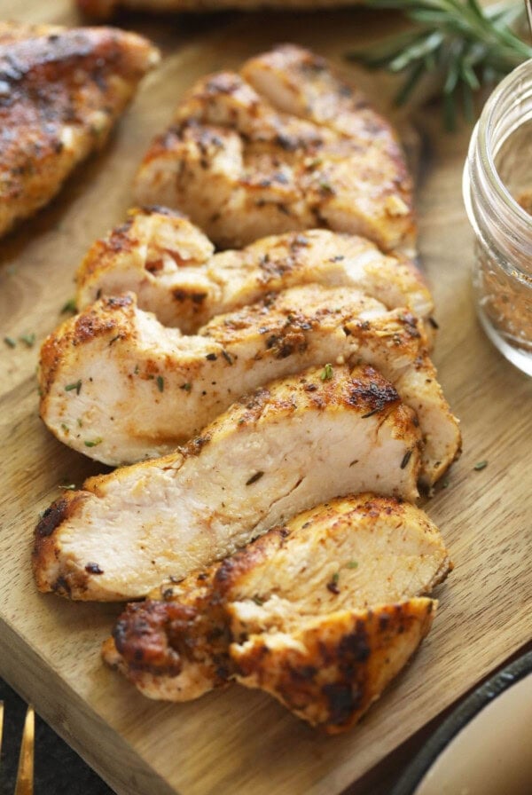 grilled chicken on a wooden cutting board.