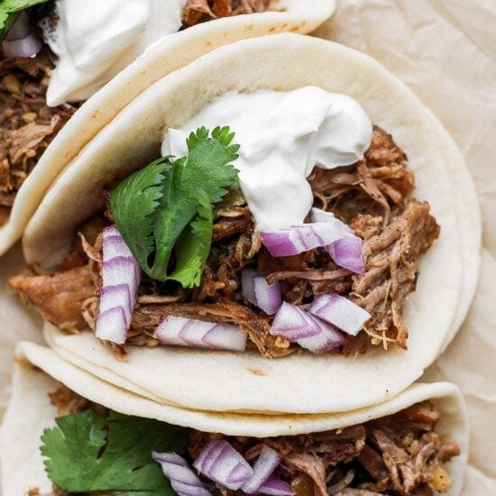 pulled pork tacos with sour cream and onions.