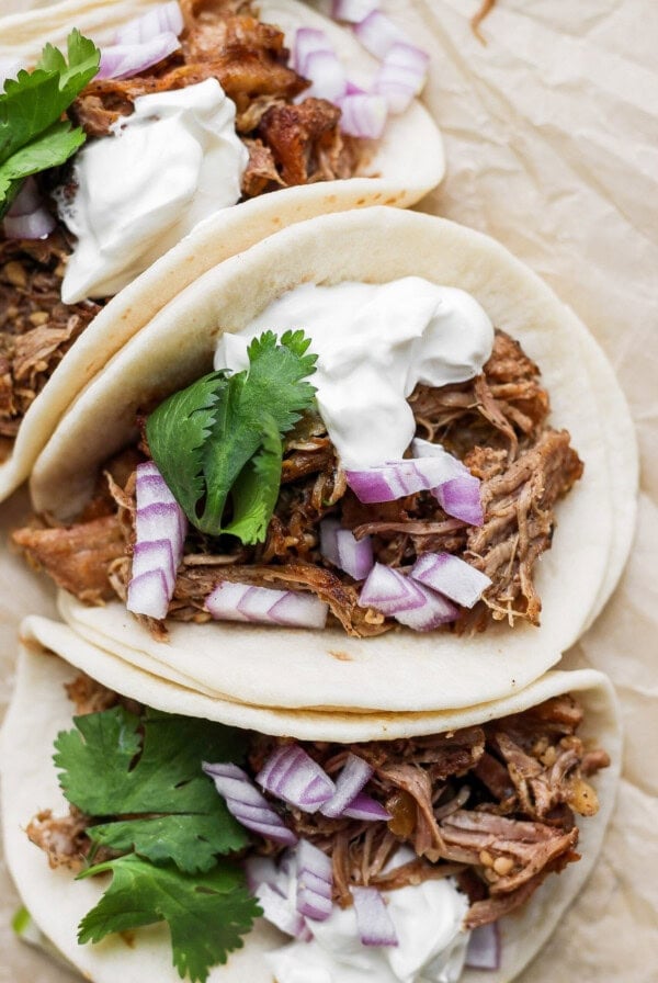 pulled pork tacos with sour cream and onions.