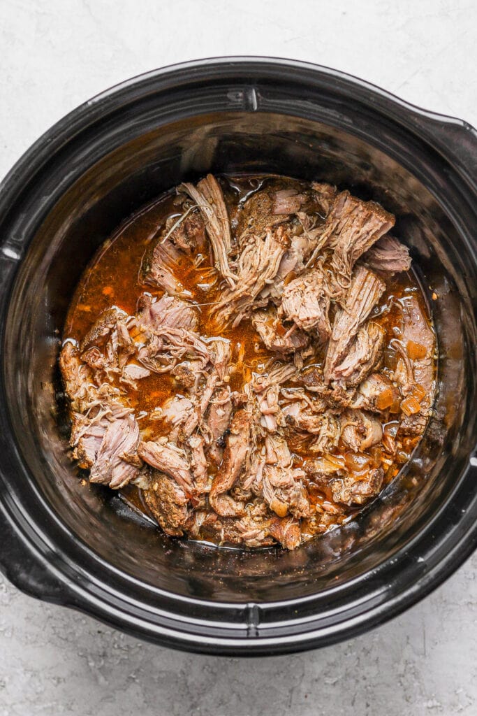 Shredded carnitas in a slow cooker. 