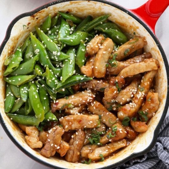 a skillet filled with chicken and green beans.