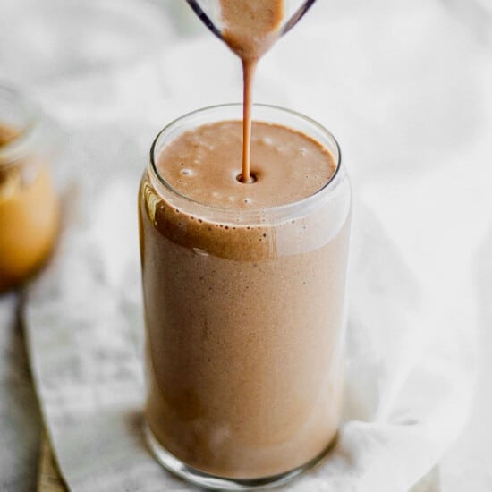 a chocolate smoothie being poured into a glass.