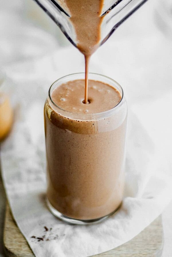 a chocolate smoothie being poured into a glass.