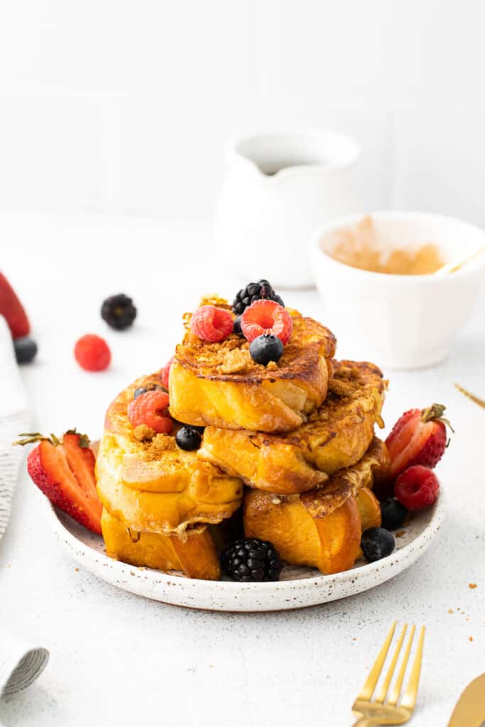 slices of french toast on a plate topped with fresh berries