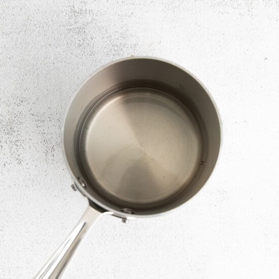 a stainless steel frying pan on a white background.