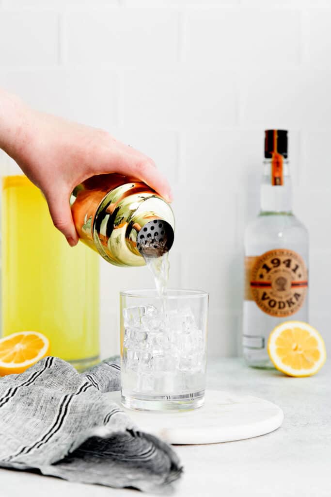 pouring vodka lemonade into glass