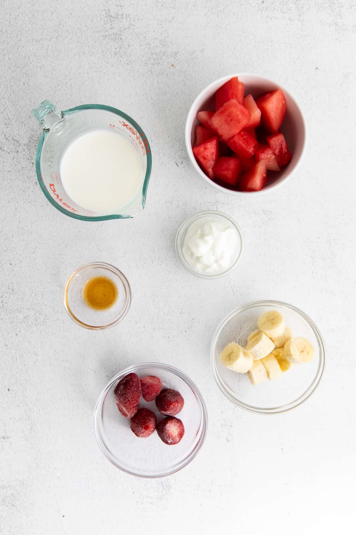 All the ingredients for the watermelon smoothie in small bowls. 