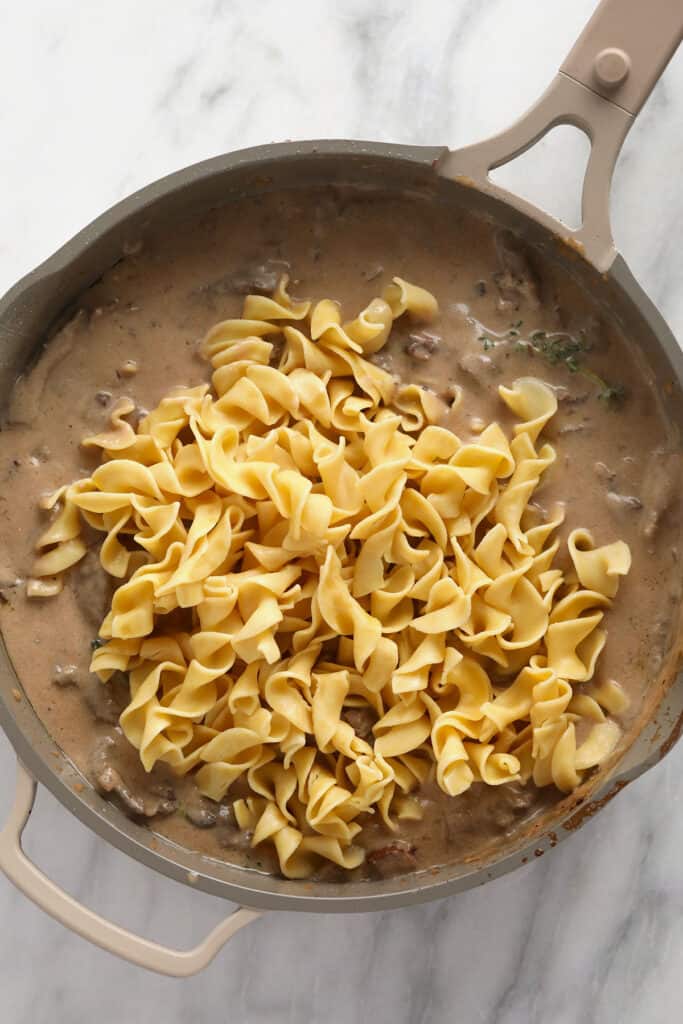 Classic beef stroganoff with egg noodles in a pan. 