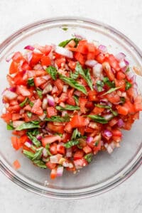 a glass bowl filled with chopped up vegetables.