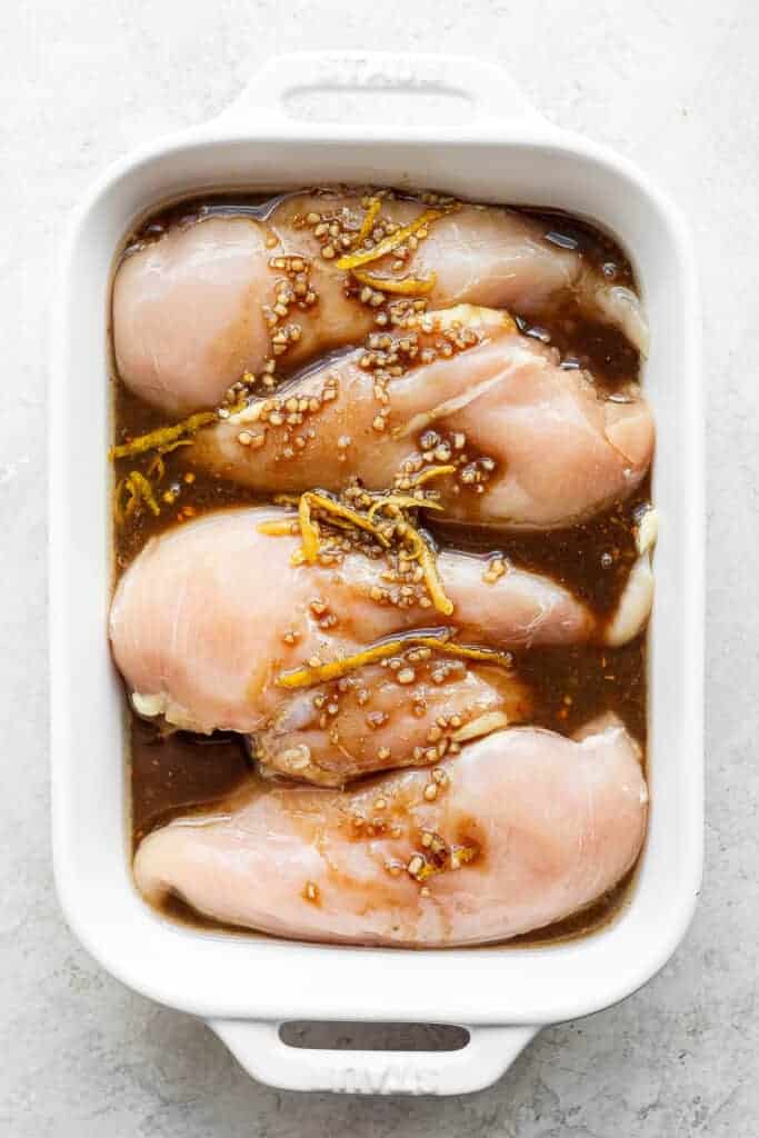 grilled chicken breast marinade in casserole dish.