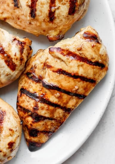 grilled chicken breasts on a white plate.
