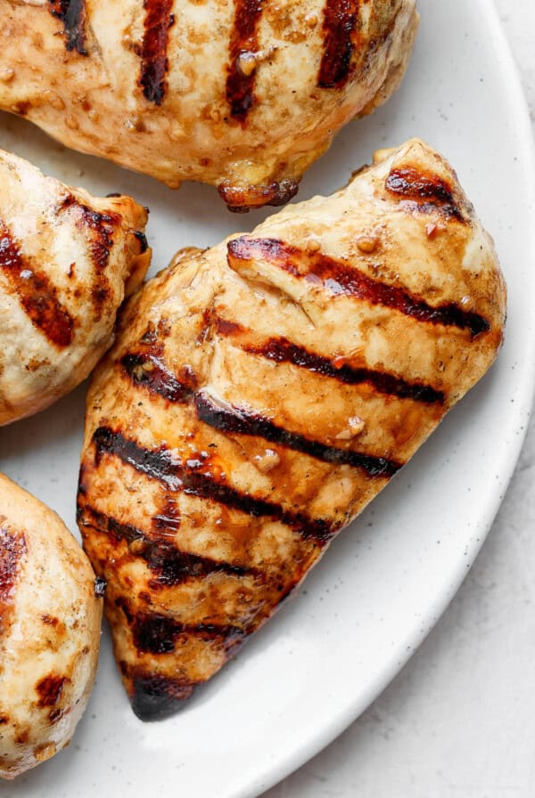 grilled chicken breasts on a white plate.