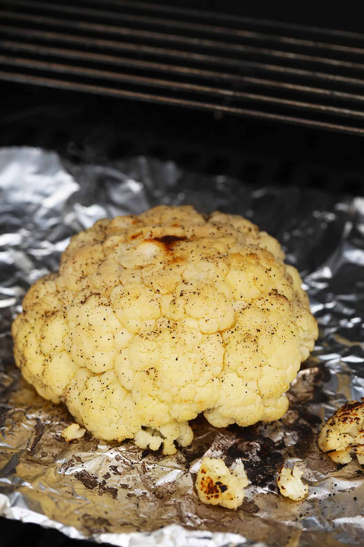 A whole head of cauliflower on the grill.