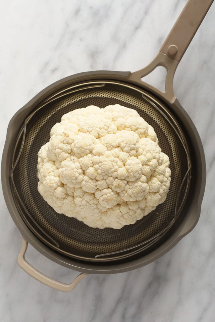 A head of cauliflower in a steamer. 