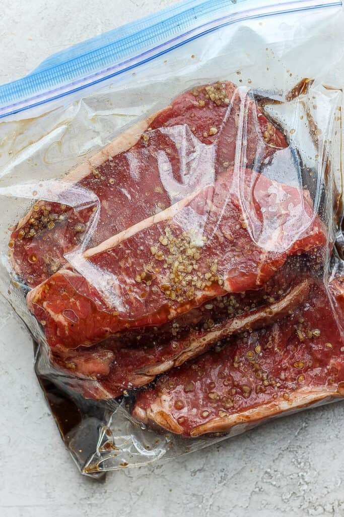 steaks marinating in plastic bag.