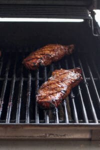 grilling steak on grill.