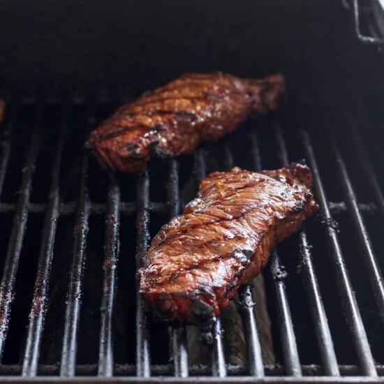 grilling steak on grill.