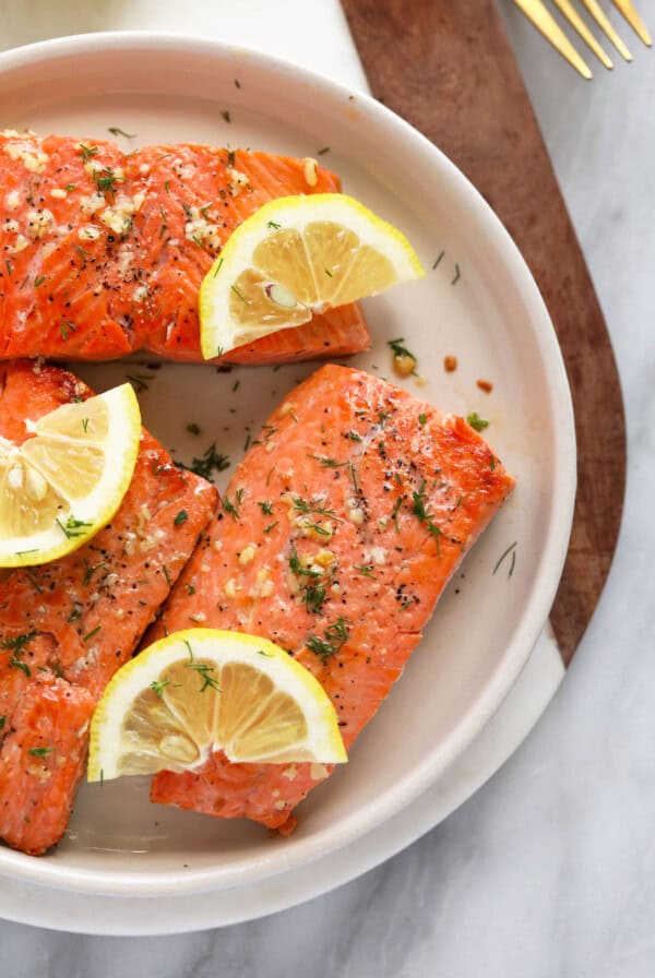 pan seared salmon on plate with fresh lemon and dill