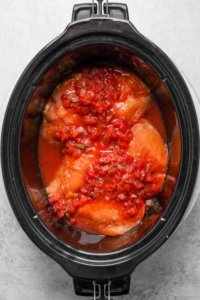 chicken breast covered in salsa in slow cooker.