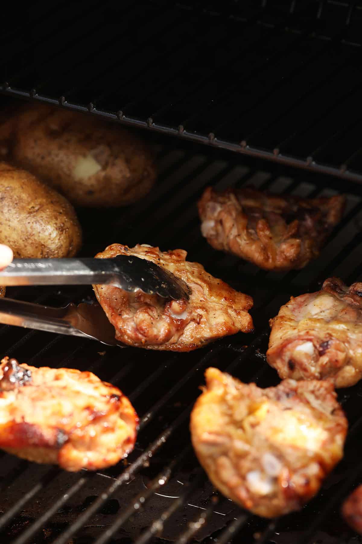 Flipping chicken thighs on a smoker. 