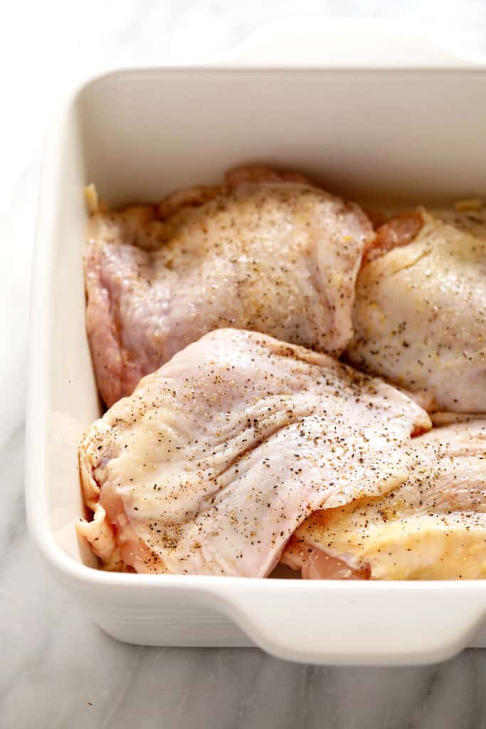 Chicken thighs marinating in a casserole dish. 