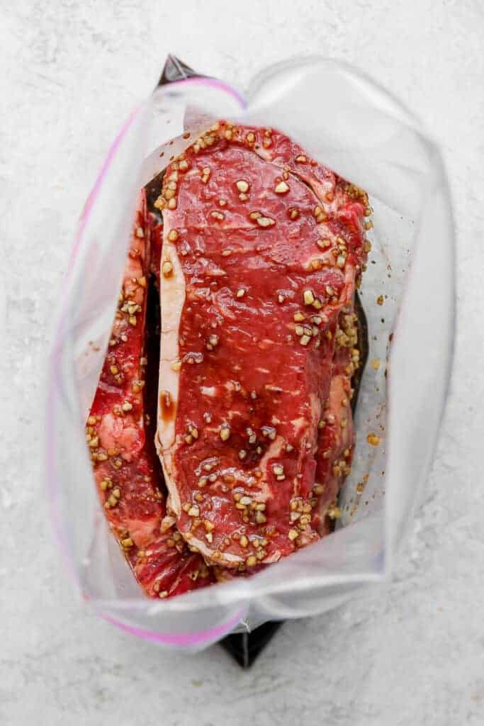 Steaks marinating in plastic bags.