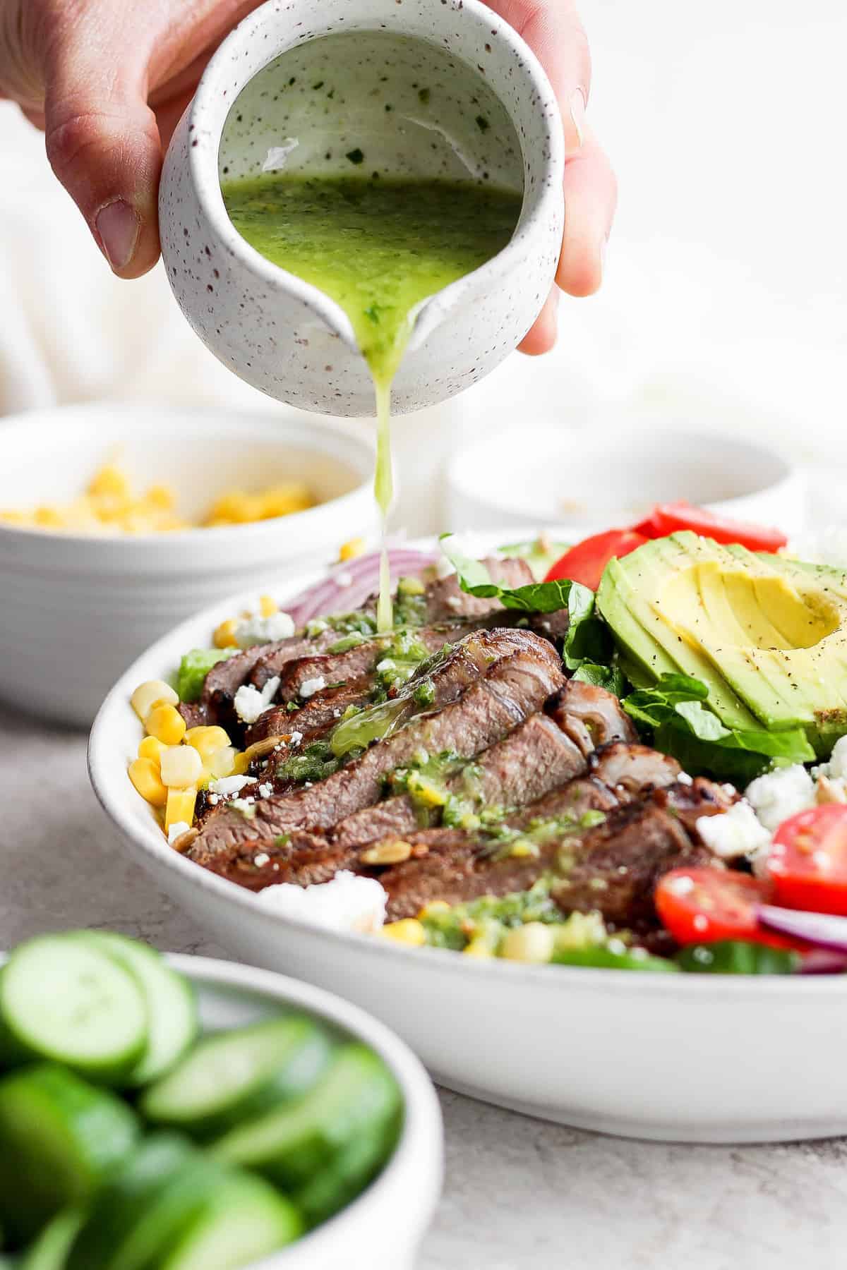 topping steak salad with dressing.