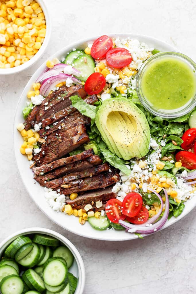 steak salad in bowl with dressing.