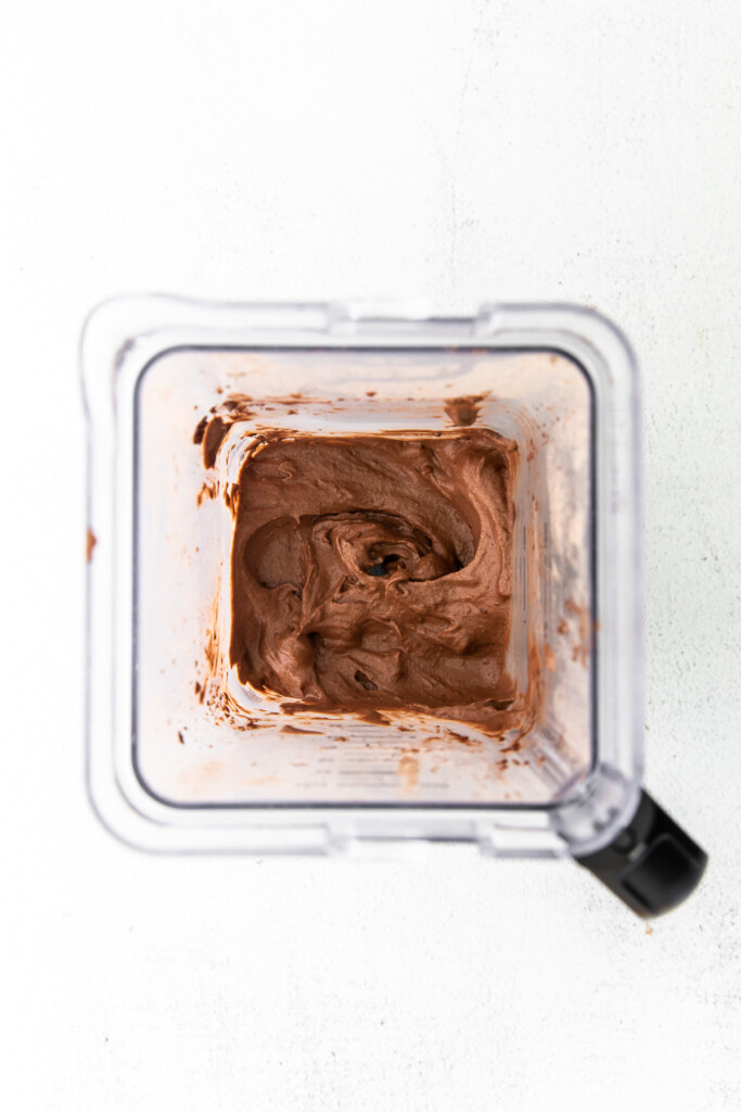 Blending chocolate protein ice cream in a blender.