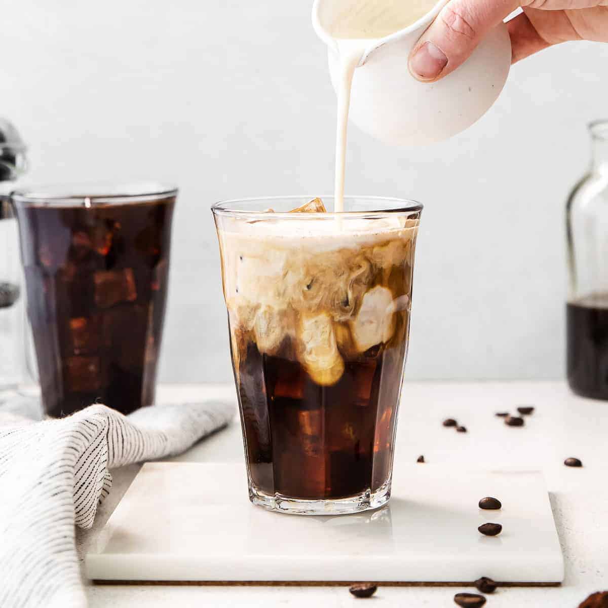 Iced coffee in jar, mug glass cup on the white table Stock Photo