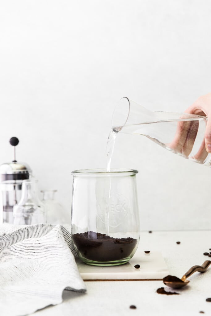 Pouring water over coffee grounds to make cold brew coffee.