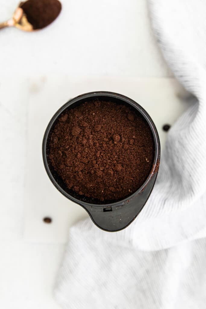 Coffee grounds in a coffee grinder. 