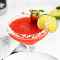 strawberry margarita with lime garnish.