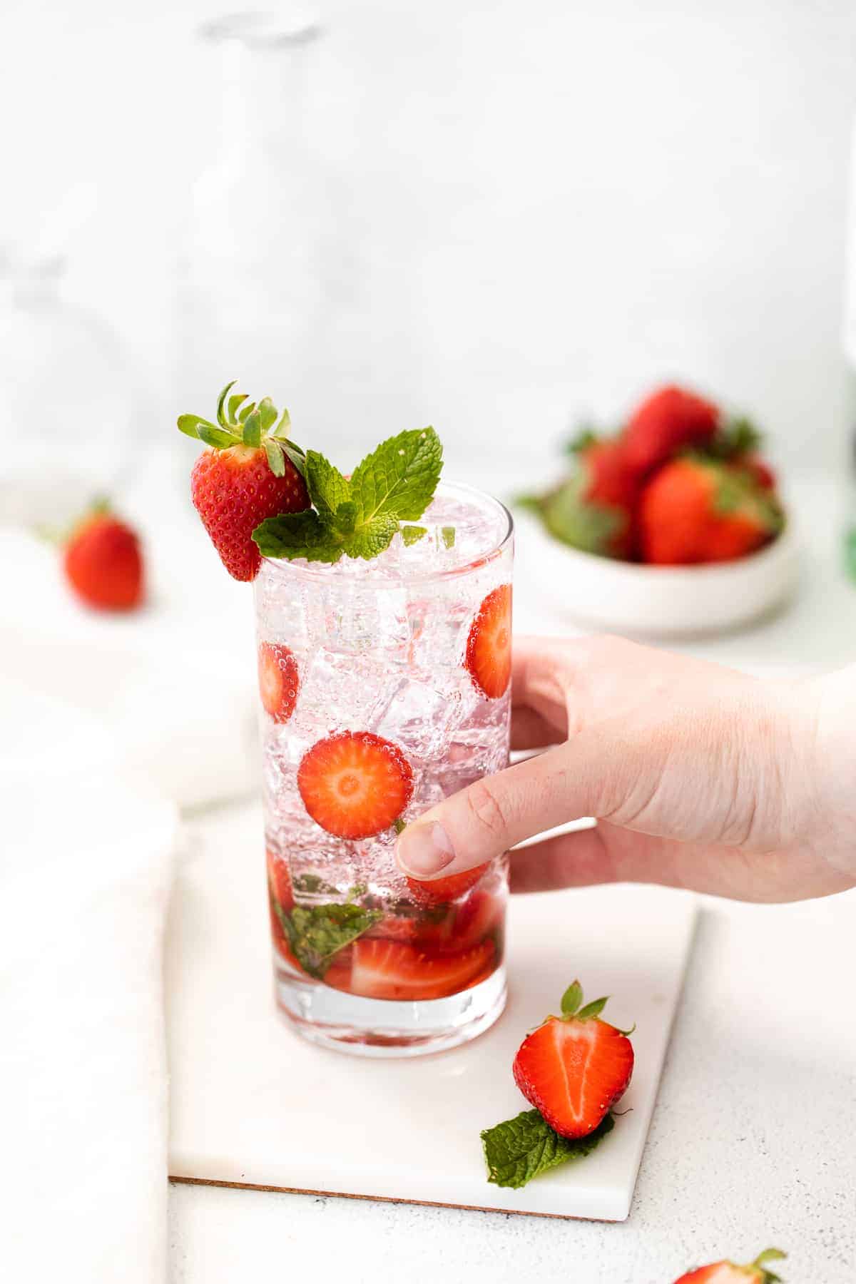 hand holding strawberry mojito