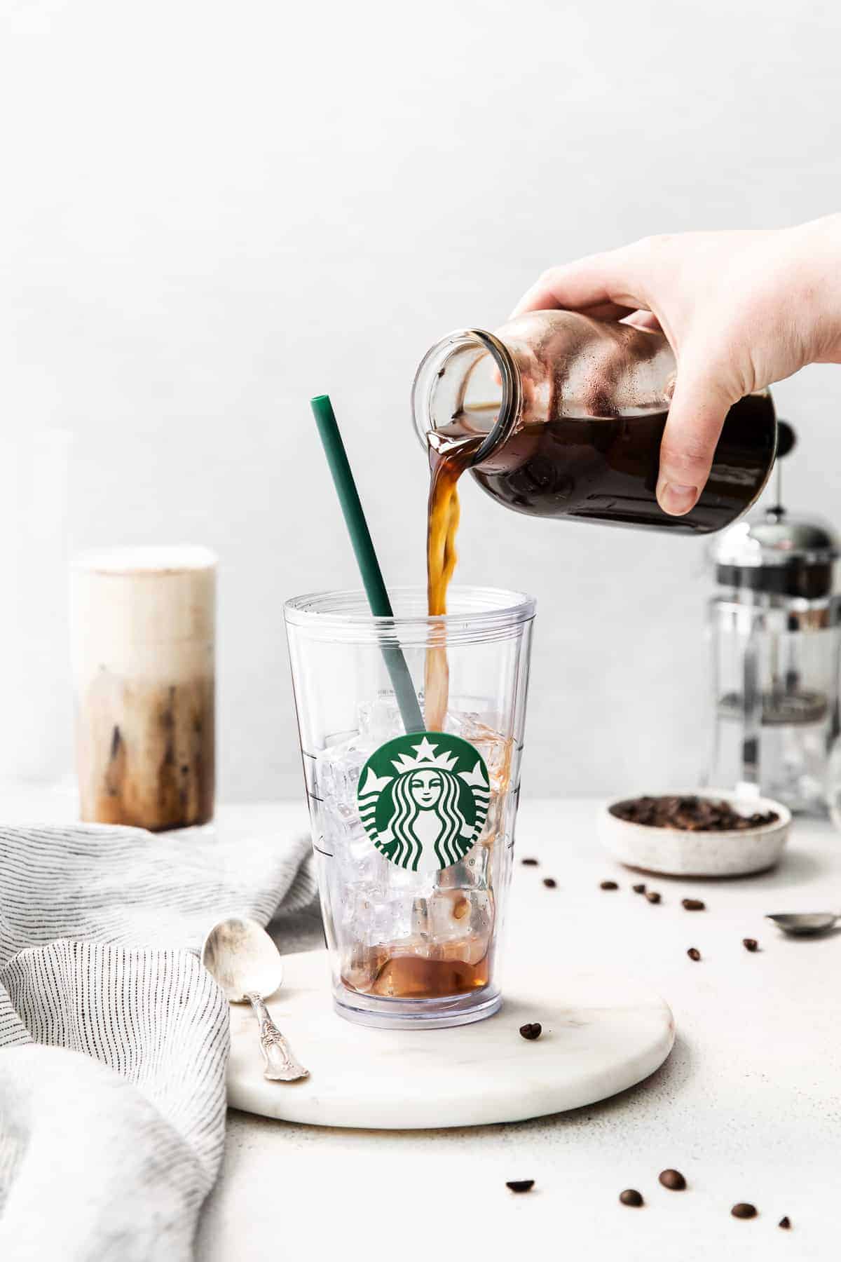 Pouring cold brew into a cup full of ice. 