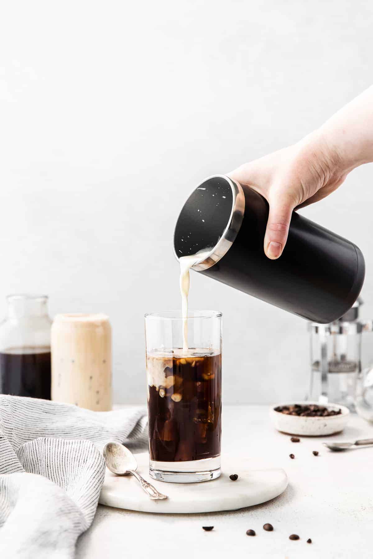 pouring sweet cream cold foam into cup.