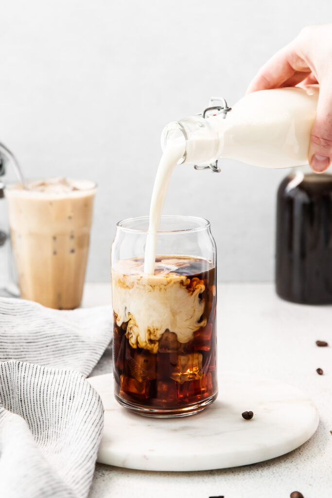 Pouring sweet cream into cold brew. 