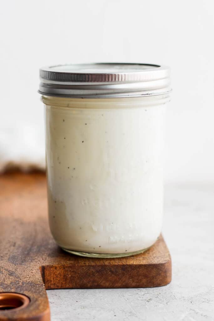 A jar full of creamy caesar dressing. 