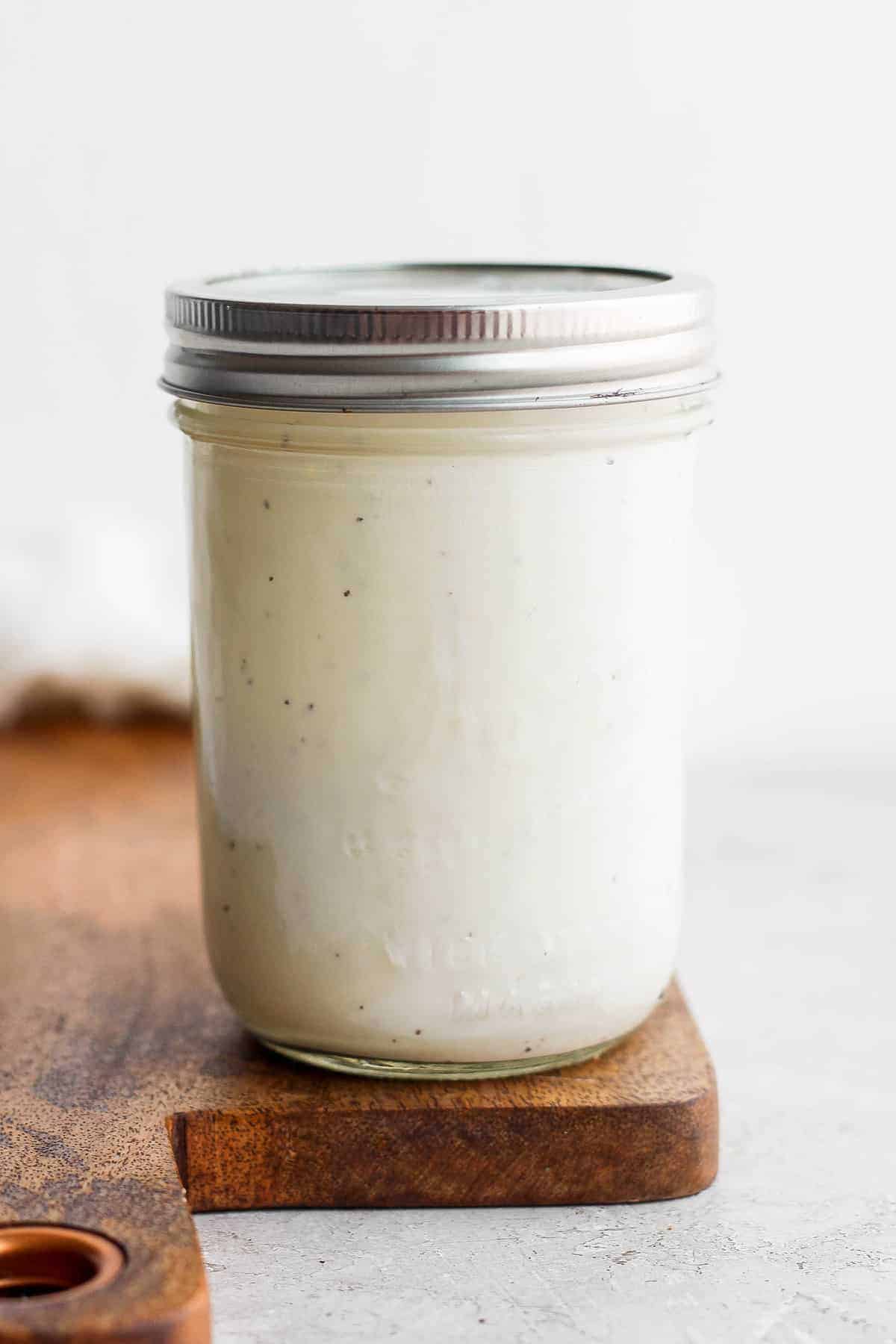 A jar full of creamy caesar dressing. 