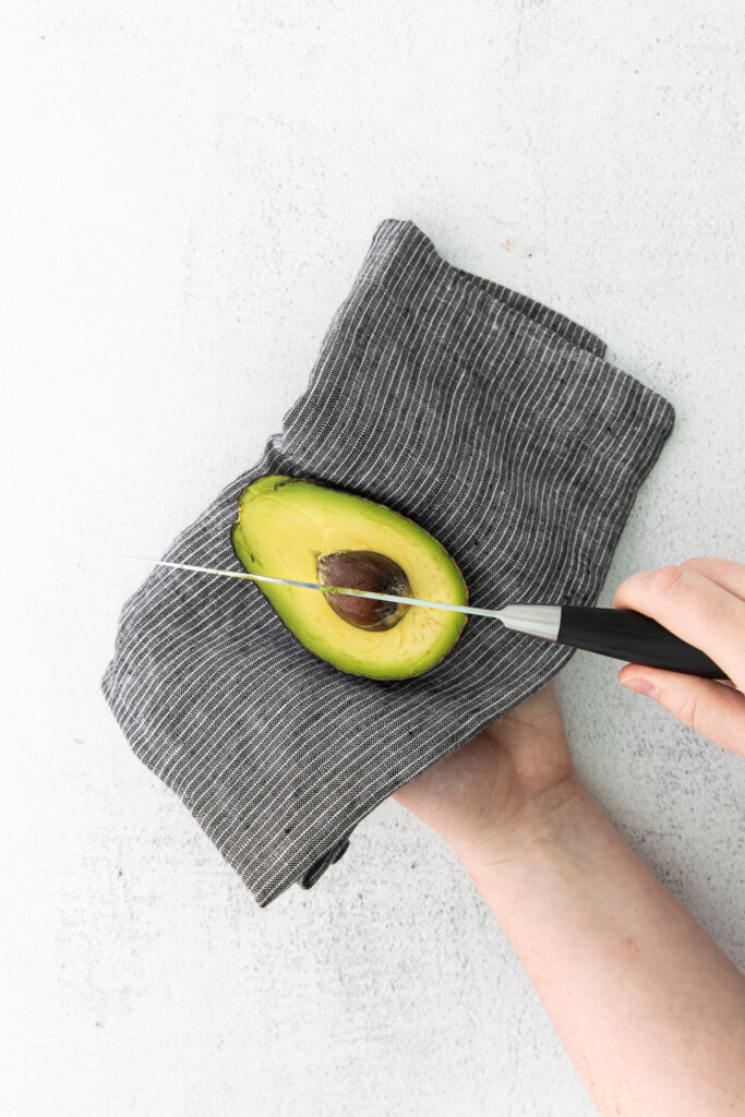 Cutting the pit out of a ripe avocado. 