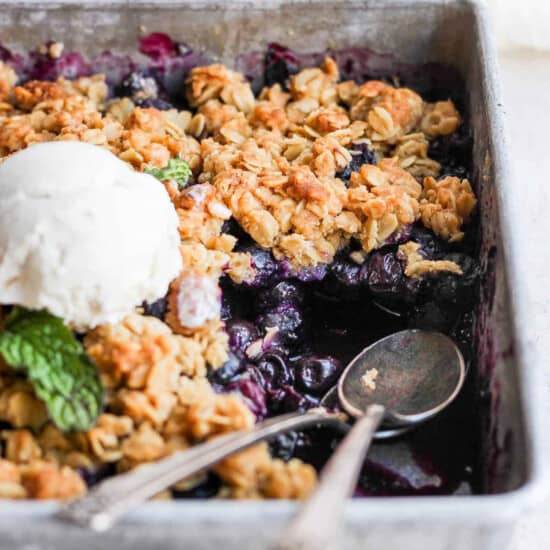 Blueberry crisp in a pan with ice cream.