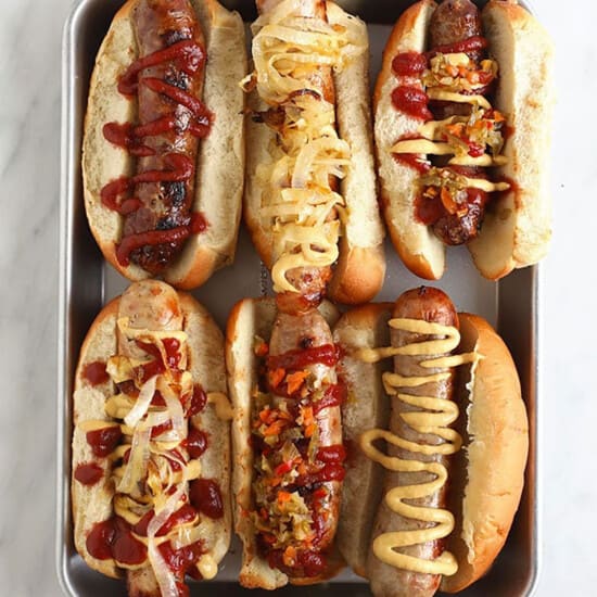 a tray of hot dogs with different toppings.