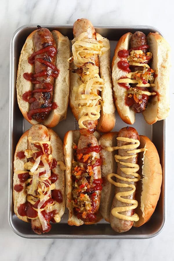 a tray of hot dogs with different toppings.